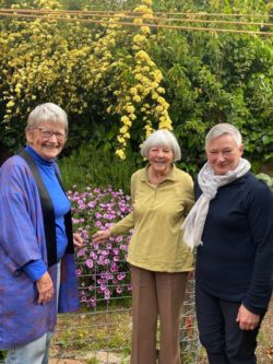 Pat, Moira & Glenda stand in front of Pat's colourful garden