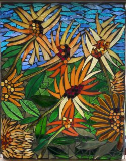 Stained glass pieces arranged into scene of flowers in a garden, against blue background.