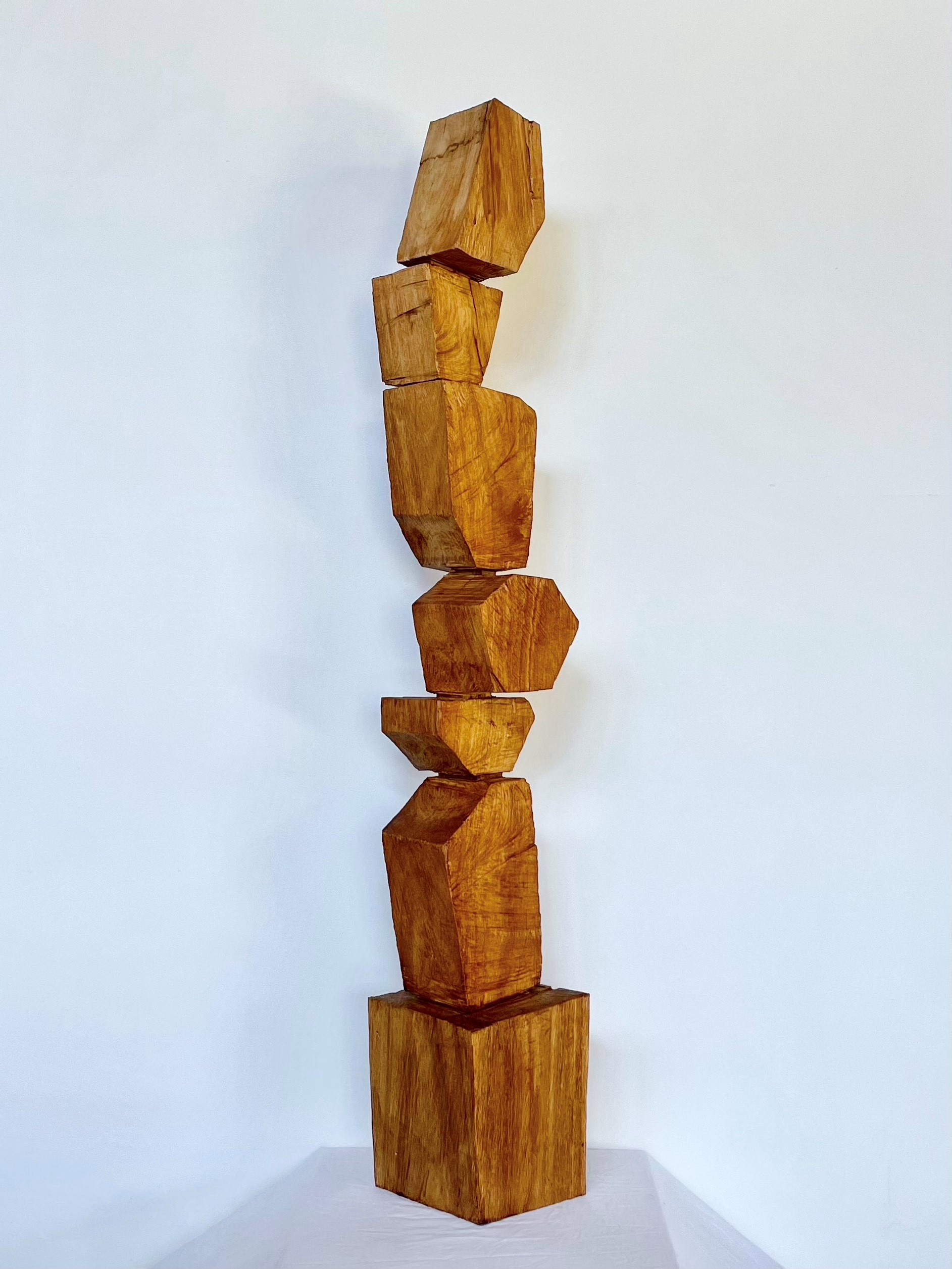 Timber sculpture of asymetric shapes stacked on top of each other to form a trophy